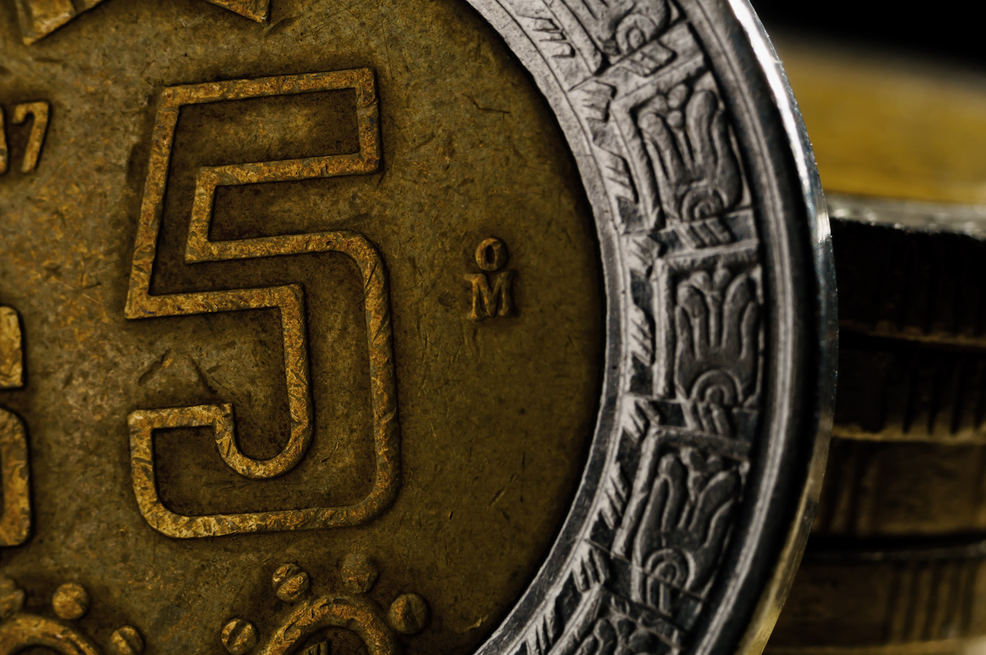 26. Съёмка частей монеты крупным планом. Эти 5 мексиканских песо смотрятся живее из-за бликов в правом верхнем углу от вспышки, размещенной позади монеты.